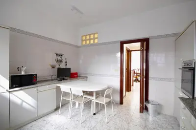 a white kitchen with a white table and chairs at HC - Baldo degli Ubaldi Elegant Apartment in Rome