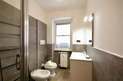 a bathroom with a toilet and a sink and a window at HC - Baldo degli Ubaldi Elegant Apartment in Rome