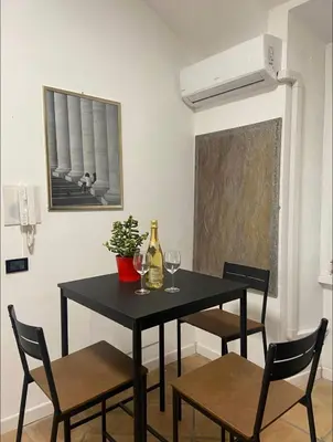 a dining room with a black table with chairs and wine glasses at Cozy Colosseo in Rome