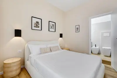 a white bedroom with a white bed and a window at Urbana 24 in Rome