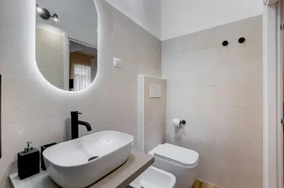 a bathroom with a sink and a toilet and a mirror at Urbana 24 in Rome