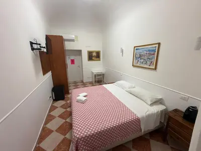 a bedroom with a bed with a pink and white blanket at ROMA Classica in Rome