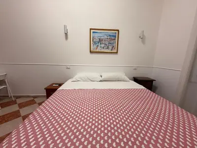 a bedroom with a bed with a red and white blanket at ROMA Classica in Rome