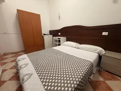 a bedroom with a large bed with a wooden headboard at ROMA Classica in Rome