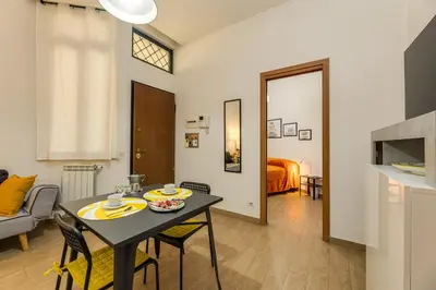 a kitchen and living room with a table and chairs at Roger apt in Rome