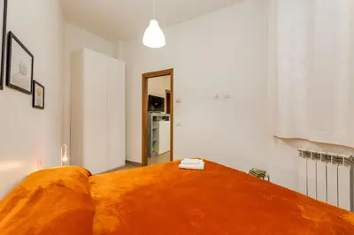 a bedroom with a bed with an orange blanket at Roger apt in Rome