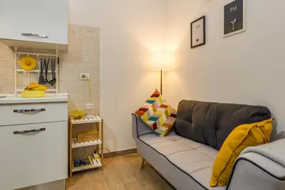 a living room with a couch and a kitchen at Roger apt in Rome