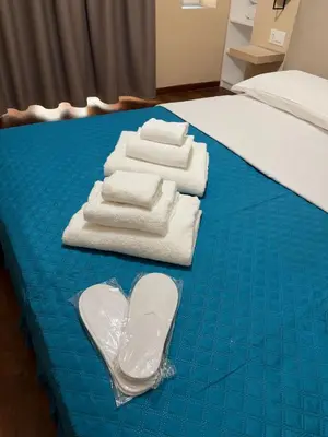 a bed with towels on a blue sheet at Le Vie di San Pietro Guest House in Rome