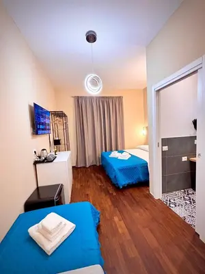 a bedroom with two beds and a mirror at Le Vie di San Pietro Guest House in Rome