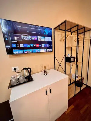 a kitchen with a white counter with a tv on the wall at Le Vie di San Pietro Guest House in Rome