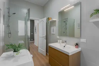 a white bathroom with a sink and a shower at VATICAN VIBE Apt in Rome