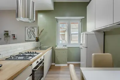 a kitchen with green walls and a stove top oven at VATICAN VIBE Apt in Rome