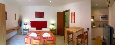 a bedroom with a bed and a table and a kitchen at Appartamento con terrazza vicino al Vaticano in Rome