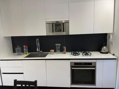 a kitchen with white cabinets and a stove top oven at Veio Loft in Rome