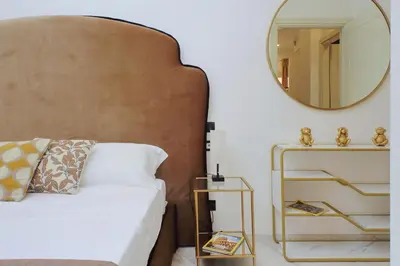 a bedroom with a white bed and a mirror at Duplex Elegante a 2 Min dal Vaticano e dalla Metro in Rome