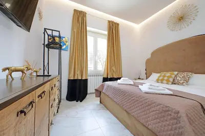 a bedroom with a large bed with a dresser and window at Duplex Elegante a 2 Min dal Vaticano e dalla Metro in Rome