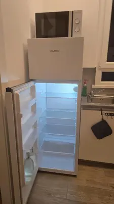 an empty refrigerator with its door open in a kitchen at Domus Regis Rooms in Rome