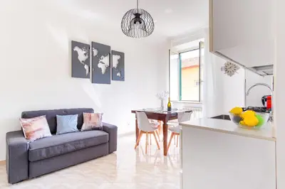 a kitchen and living room with a couch and a table at Elegantis Labicana Apartment - Few steps from the Colosseum in Rome