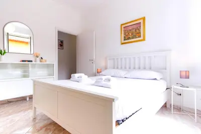 a white bedroom with a bed and a mirror at Elegantis Labicana Apartment - Few steps from the Colosseum in Rome