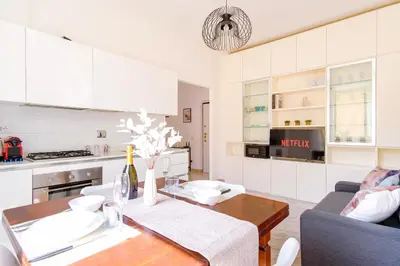 a kitchen and living room with a table and a couch at Elegantis Labicana Apartment - Few steps from the Colosseum in Rome