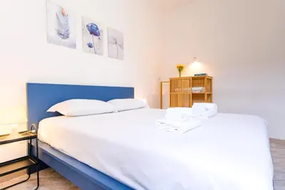 a bedroom with a large bed with white sheets at Elegantis Labicana Apartment - Few steps from the Colosseum in Rome