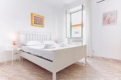 a white bedroom with a white bed and a window at Elegantis Labicana Apartment - Few steps from the Colosseum in Rome