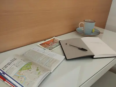a table with a book and a cup and a pen at Dimora Roma Eterna, vacation & business in Rome