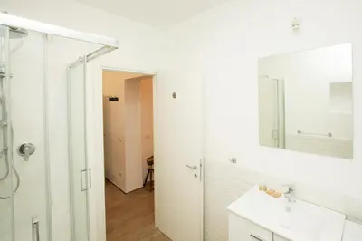 a white bathroom with a sink and a mirror at Manara10 Apart Blu1 in Rome