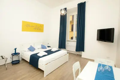 a bedroom with a bed and a table and a tv at Manara10 Apart Blu1 in Rome
