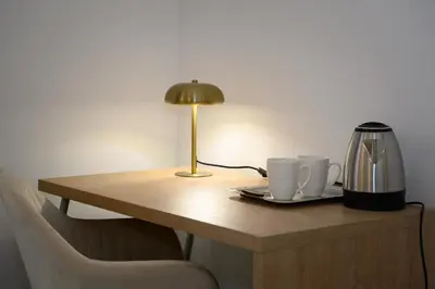 a table with two coffee cups and a lamp on it at Magnoliahome Suites at the Vatican in Rome