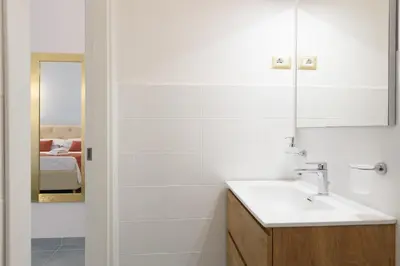 a white bathroom with a sink and a mirror at Magnoliahome Suites at the Vatican in Rome