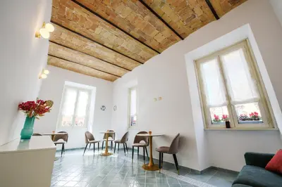a living room with a table and chairs and windows at Magnoliahome Suites at the Vatican in Rome