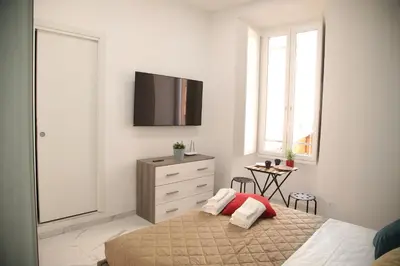 a bedroom with a bed and a tv on the wall at Emma and Livia's Vatican Suite 2 in Rome