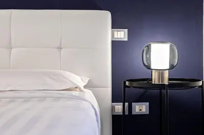 a bedroom with a bed and a mirror on a side table at Casa Sistina in Rome