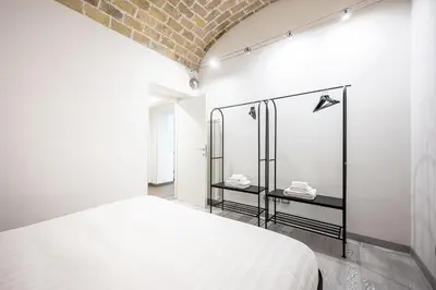 a bedroom with a white bed and a brick wall at Casa Sistina in Rome