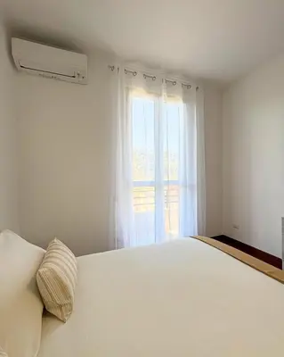 a bedroom with a white bed and a window at Casa Alice Near Vatican City - Modern, High Floor with View in Rome