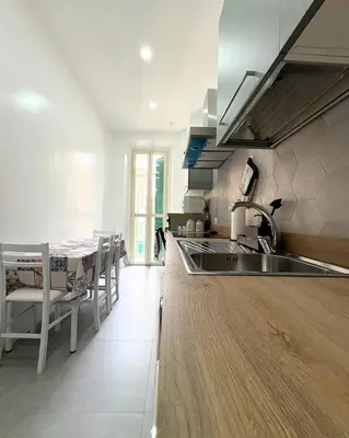 a kitchen with a sink and a table with chairs at Casa Alice Near Vatican City - Modern, High Floor with View in Rome