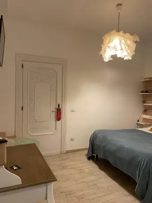 a bedroom with a bed and a table and a chandelier at Room of Arts in Rome