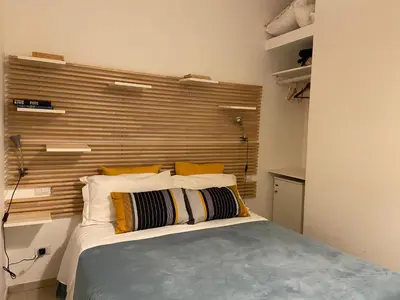 a bedroom with a bed with a large wooden headboard at Room of Arts in Rome