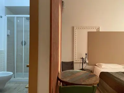 a bathroom with a table and a bed and a tub at Room of Arts in Rome