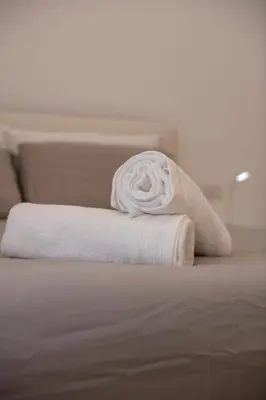 a rolled up white towel sitting on a bed at Appartamento Roma - Bredi Home in Rome