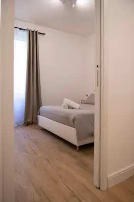 a white bedroom with a bed and a window at Appartamento Roma - Bredi Home in Rome