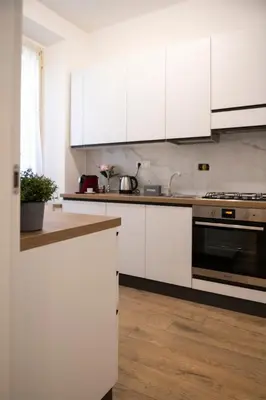 a kitchen with white cabinets and a stove top oven at Appartamento Roma - Bredi Home in Rome