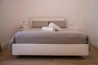 a large white bed with two pillows on it at Appartamento Roma - Bredi Home in Rome
