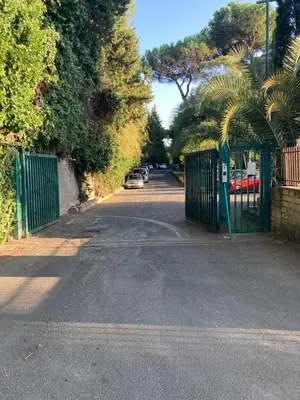 a gate to a parking lot with a car on a street at Terracito! in Rome