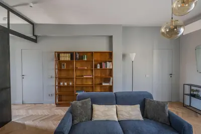 a living room with a blue couch and a book shelf at Terrace Apartment Monte del Gallo by St Peter in Rome