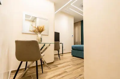 a living room with a table and a chair at Paci Luxury Suite in Rome