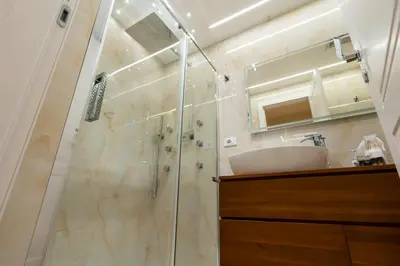 a bathroom with a shower with a sink and a mirror at Paci Luxury Suite in Rome