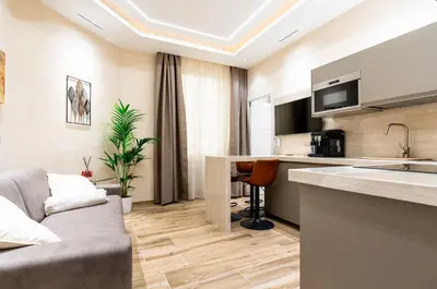 a living room with a couch and a kitchen at Paci Luxury Suite in Rome