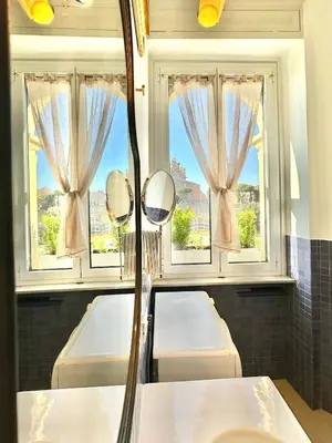 a bathroom with a mirror and two sinks and windows at Vacanze Romane Basilica in Rome